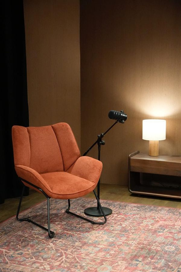 Armchair next to a sideboard lamp with a microphone on a stand, warm wood backdrop.